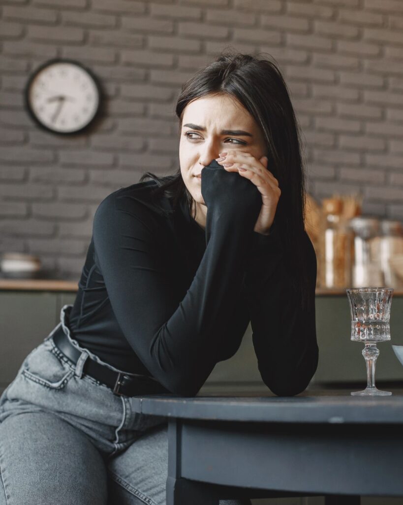 Woman standing at kitchen counter overthinking after betrayal