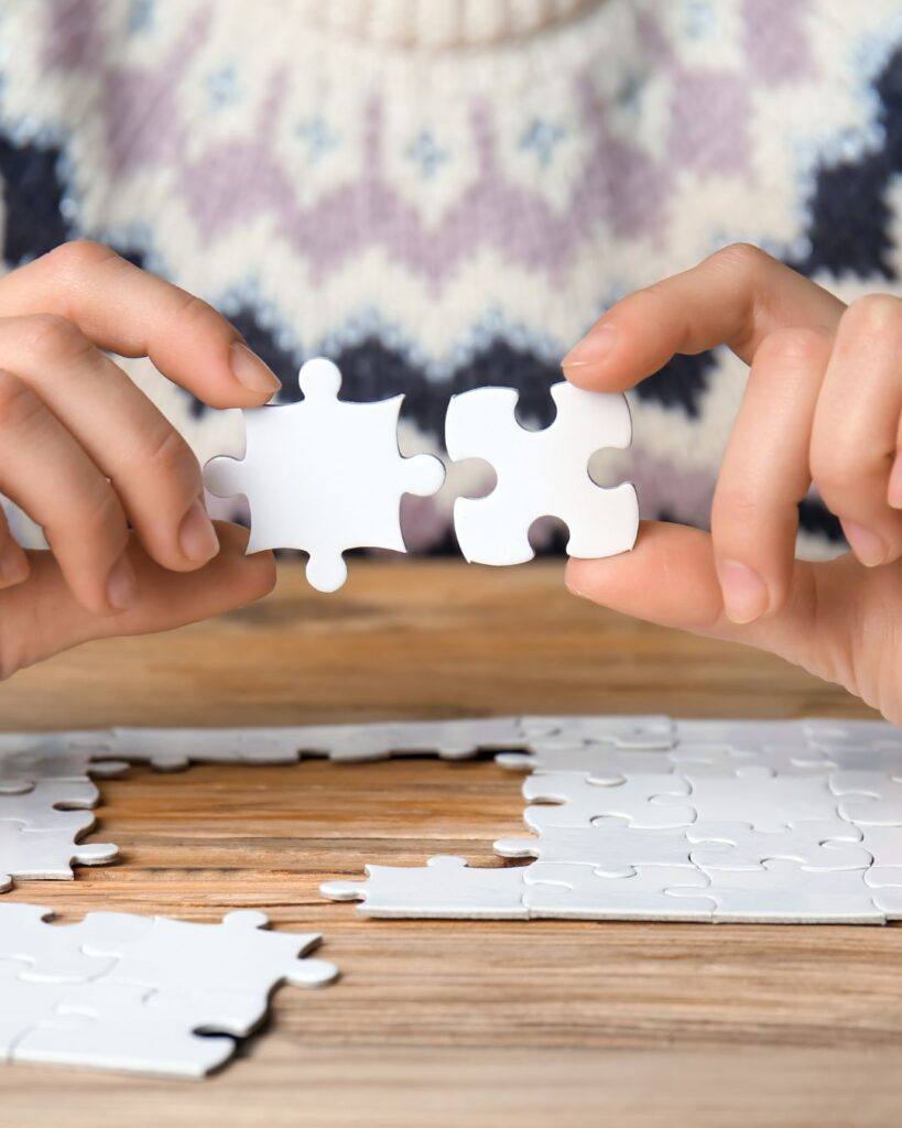 Woman holding two jigsaw pieces up against each other as she pieces together the betrayal