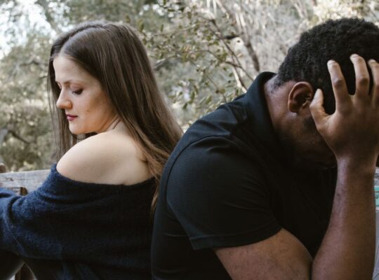 Couple with their backs to each other both looking sad and disheartened - dealing with the discovery of betrayal